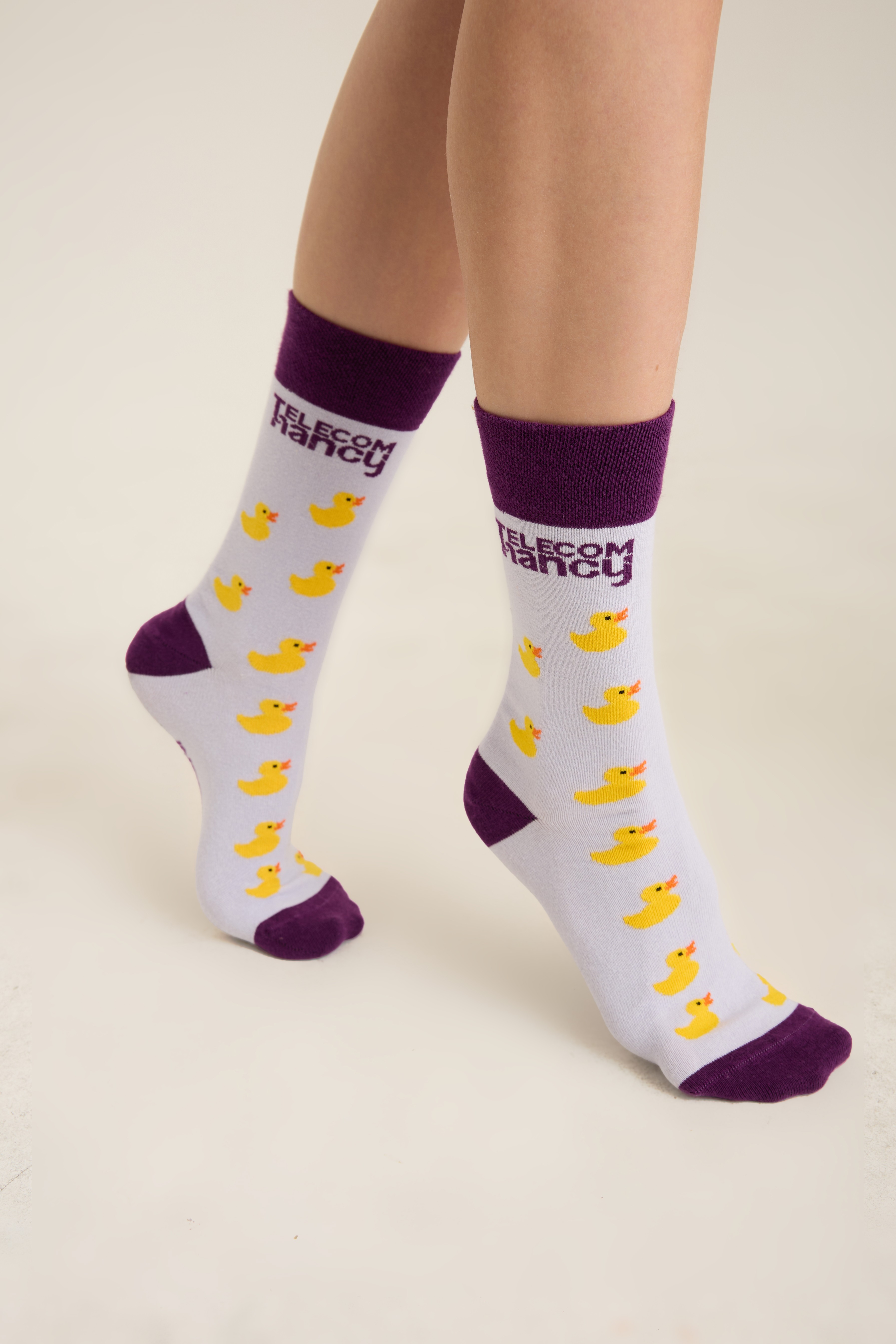 White crew socks with a yellow duck jacquard pattern and contrast cuff