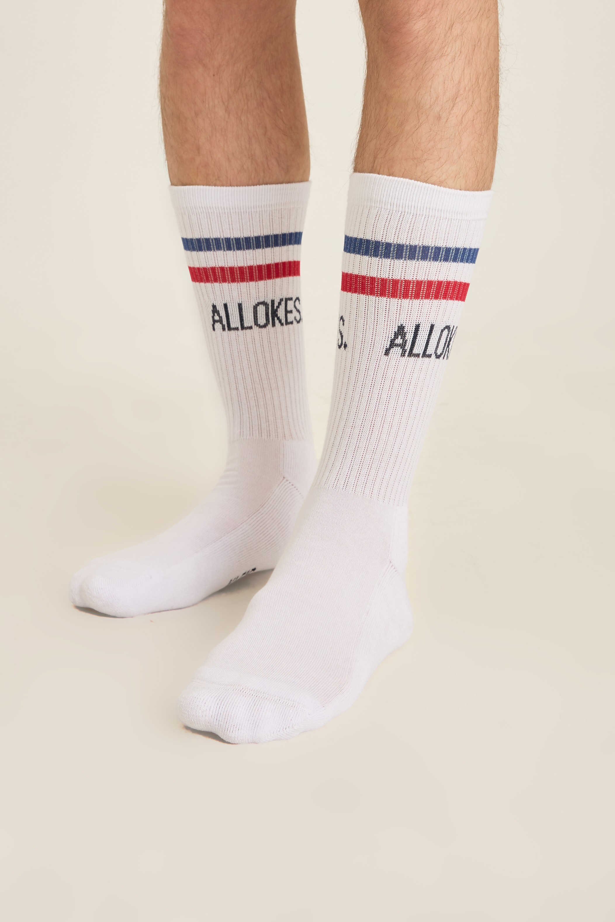 White crew socks with red and blue stripes and a knit-in brand name