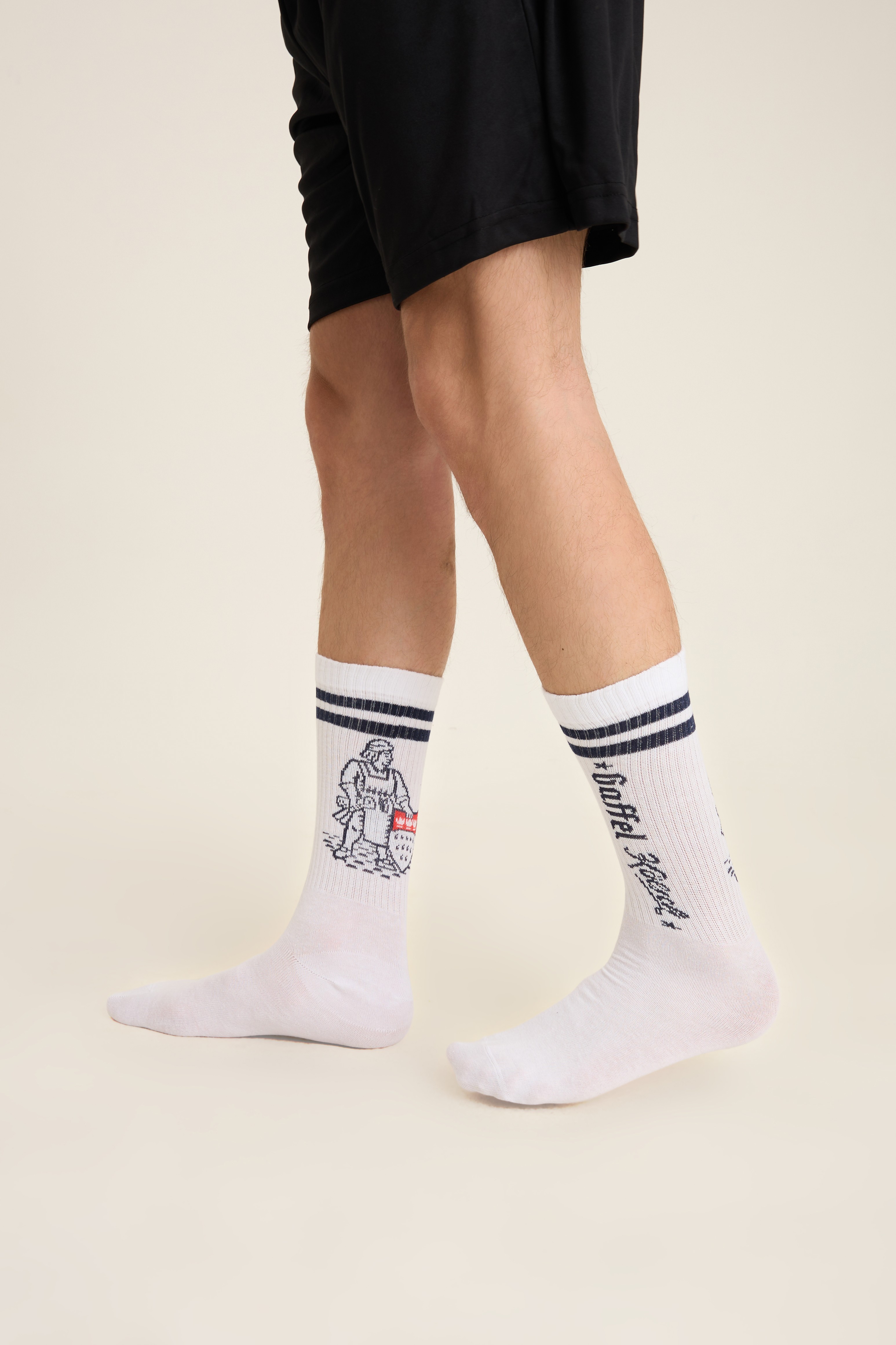 White crew socks with black stripes and a small knit motif