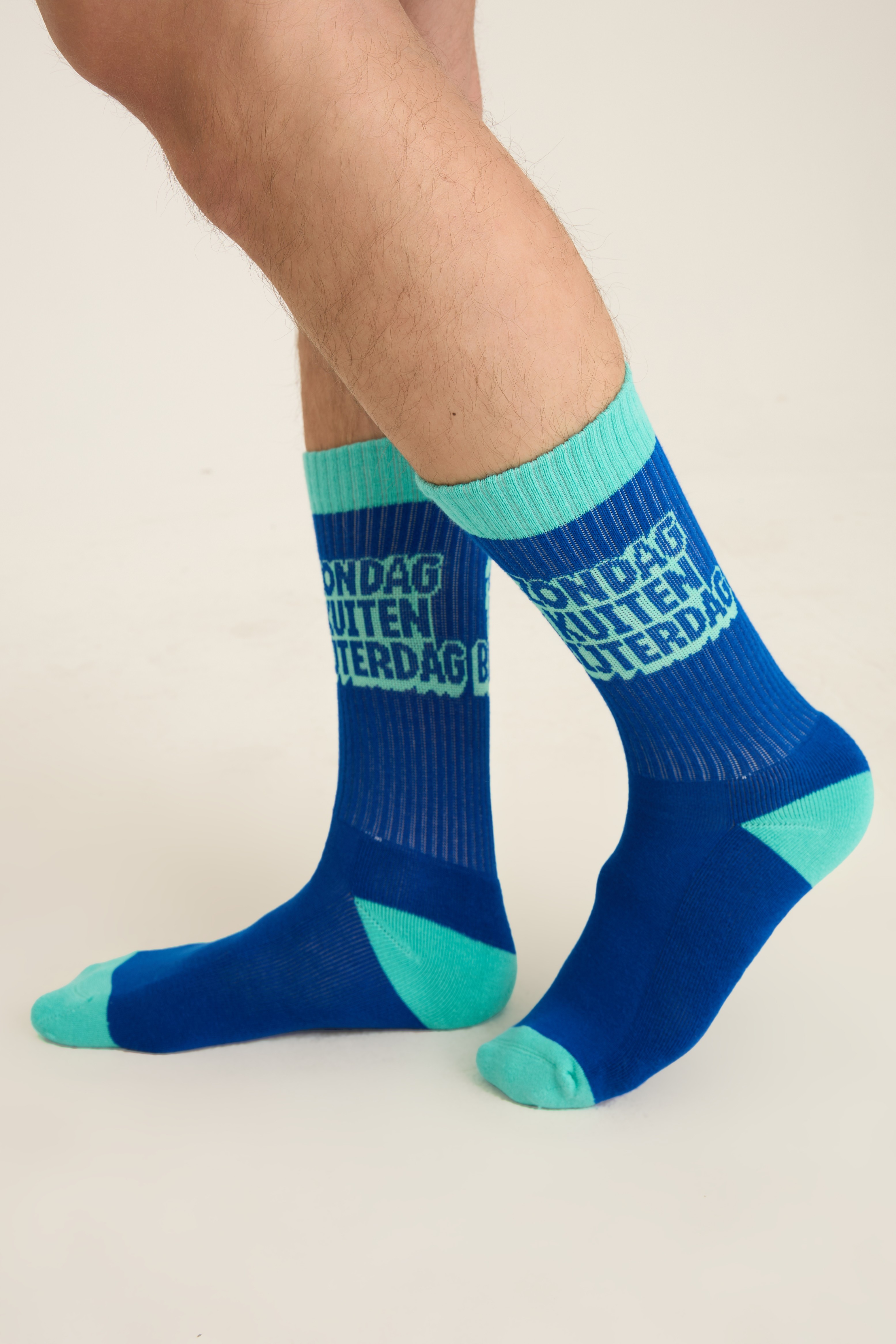 Blue socks with a geometric all-over knit pattern and teal contrast