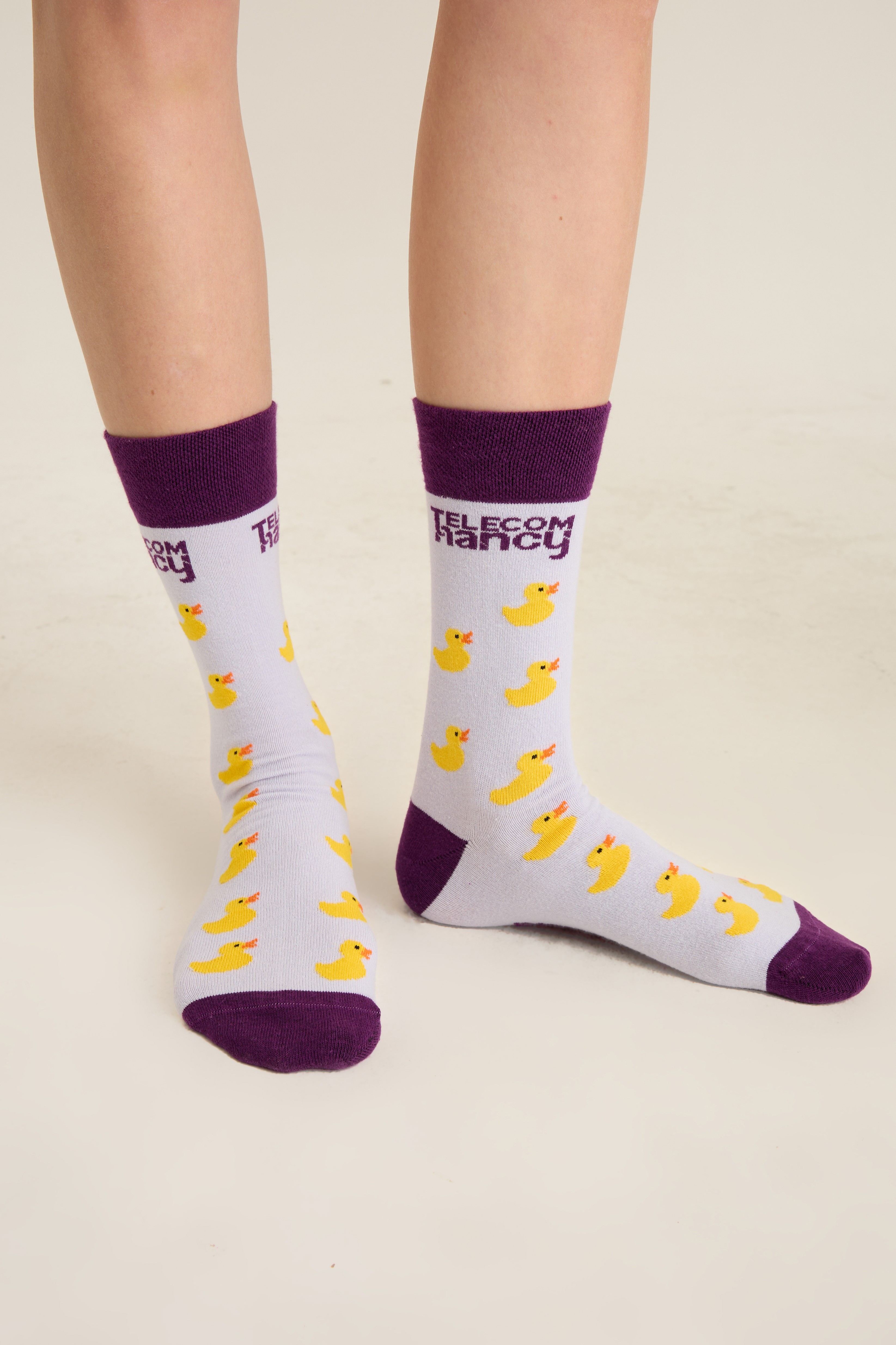 White socks with an all-over yellow duck jacquard and purple cuff, heel and toe