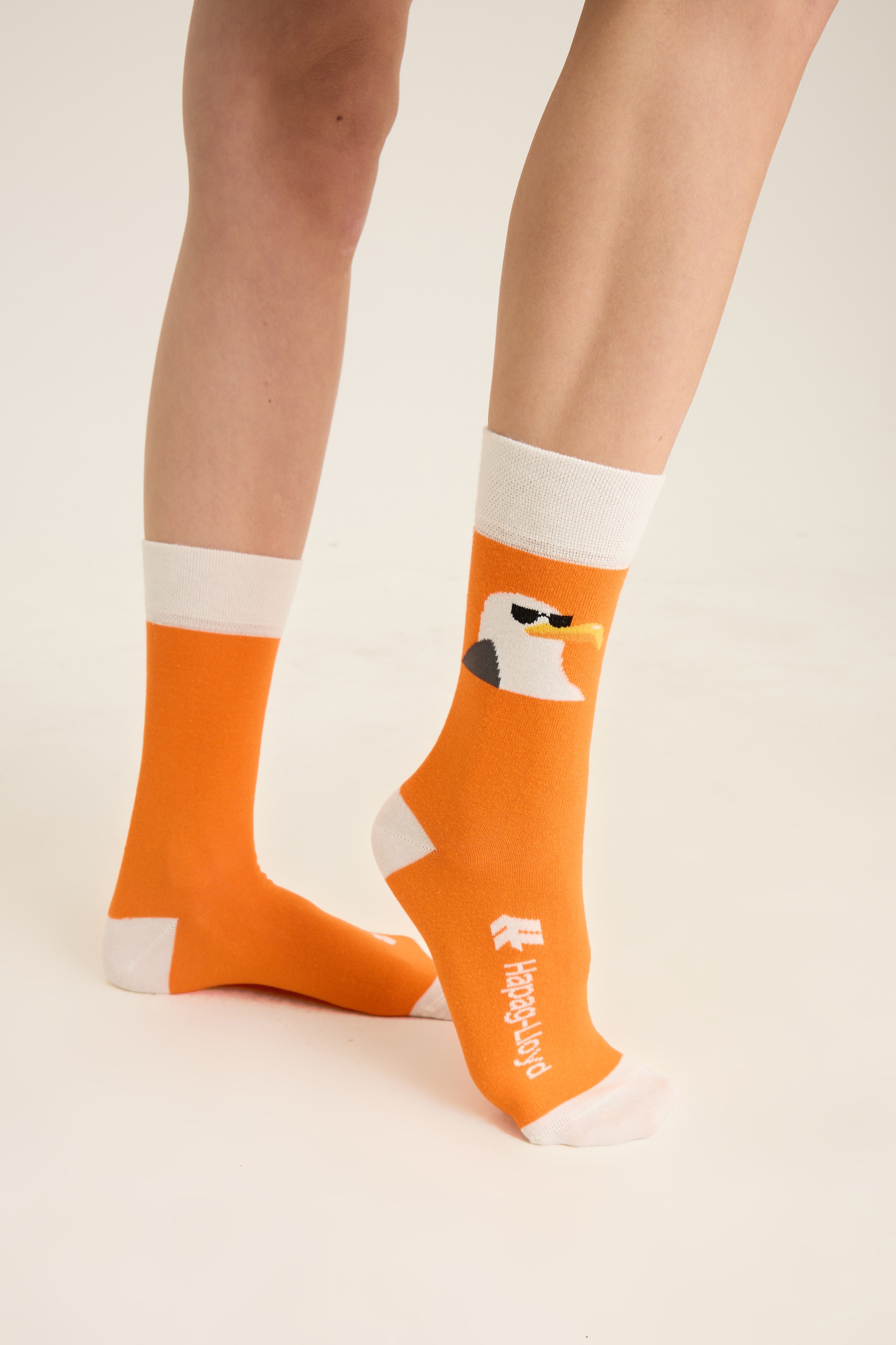 Side view of the orange character crew sock showing the knit logo on the foot