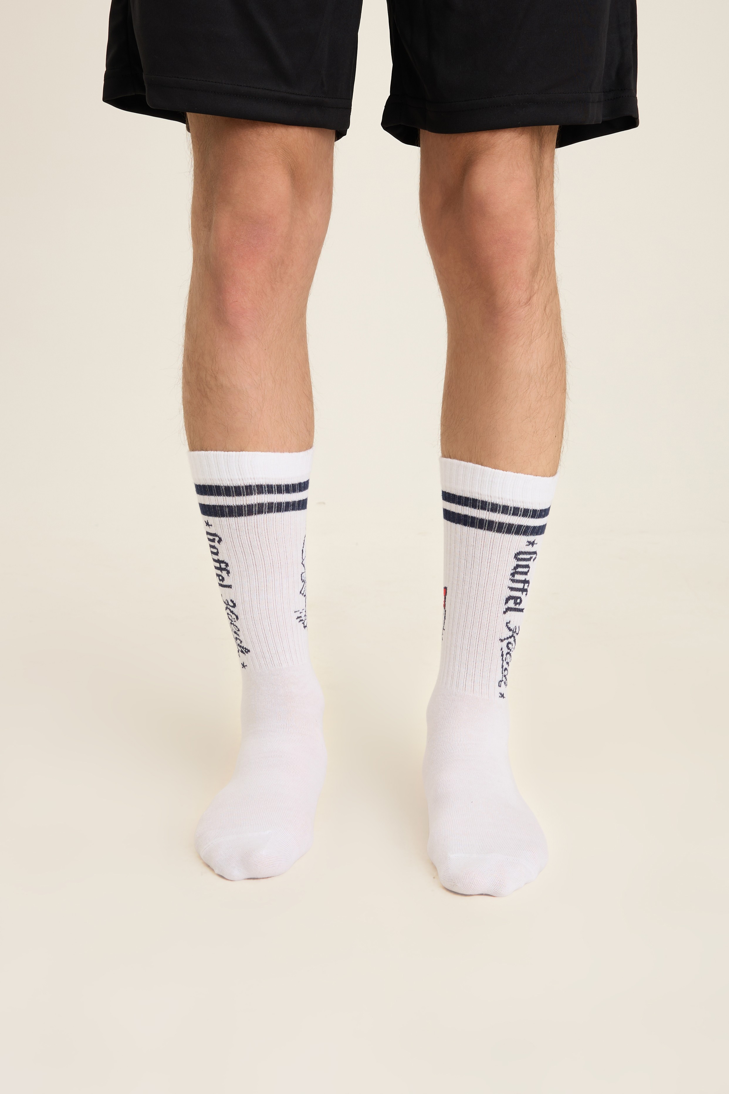 White ribbed crew socks with fine black stripes and small knit text
