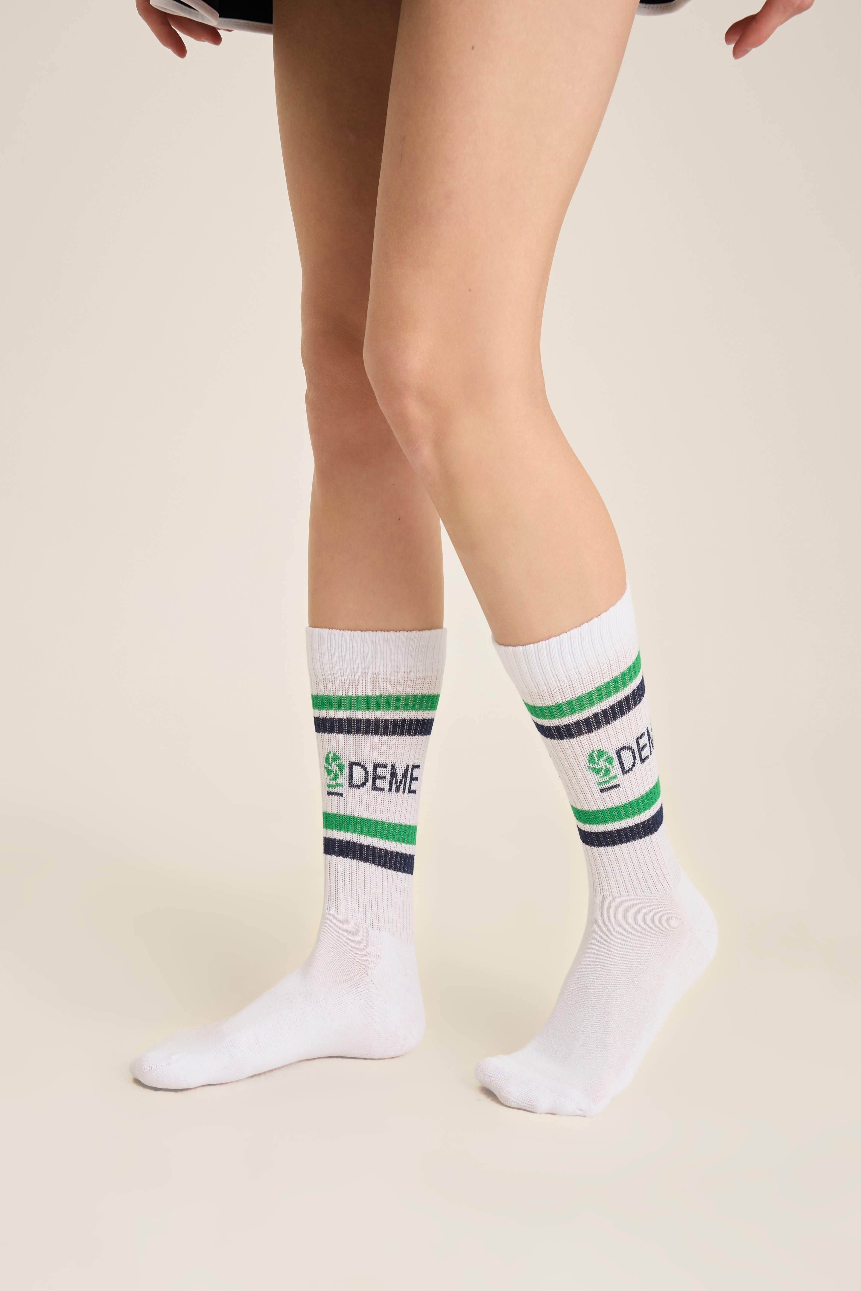 White ribbed socks with green and navy stripes and a knit-in wordmark