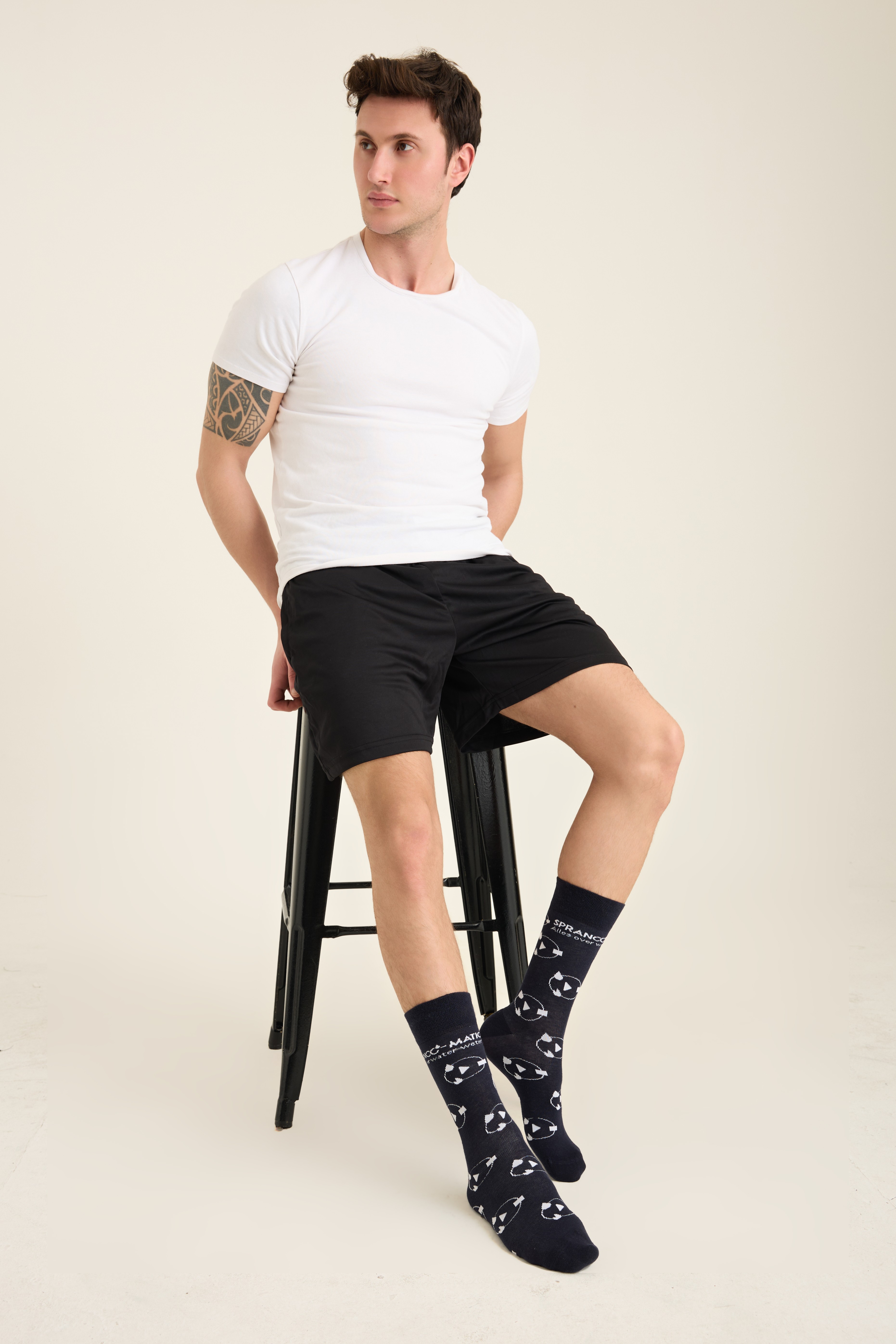Male model wearing navy all-over motif socks with knit branding
